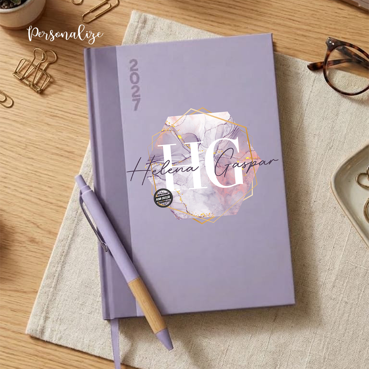 Organize o seu ano com a Agenda com caneta 2027 em tons pastel. Capa dura com ilustração mármore, iniciais e nome personalizado.&nbsp;

Planeie os seus dias com delicadeza e encanto com a agenda personalizada para 2027 em tons pastel.&nbsp;

Características Principais:

Ilustração Botânica em Aguarela: Design delicado marmoreado em destaque.

Personalização Exclusiva: Gravada com o seu nome e iniciais na capa

Detalhes Funcionais: Capa dura resistente, gravação lateral do ano "2027" na lombada e fita marcad