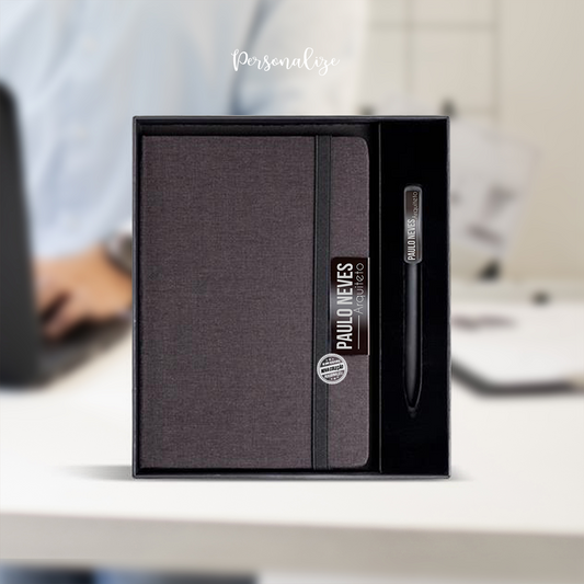 Dá um toque de elegância e personalidade ao teu dia a dia com este bloco de notas e caneta personalizado.

Conjunto de bloco A5 com capa rígida de tecido RPET,&nbsp; com um elegante detalhe metálico, para gravar nome, profissão, frase ... Contém 160 páginas de papel liso de 70g, certificado pelo FSC. Acompanha uma esferográfica de alumínio com revestimento aborrachado e clip espelhado.

O presente perfeito para quem valoriza a organização e o estilo.
Personaliza com o teu nome e profissão - o detalhe que fa