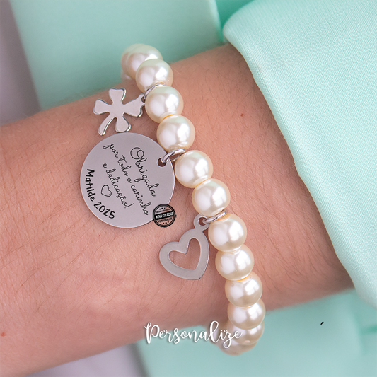 Pulseira em pérolas sintecticas personalizada para professora, educadora, auxiliar, monitora ou até para catequista com elástico e medalha em aço inóx personalizada. Um presente super giro e económico que vai surpreender que recebe.&nbsp;
Agradeça de forma super especial a quem mais merece.
